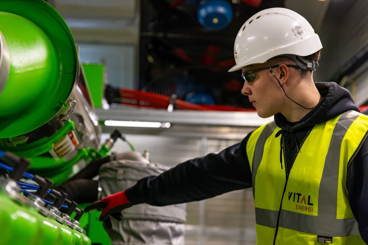 Técnico con casco inspeccionando maquinaria industrial