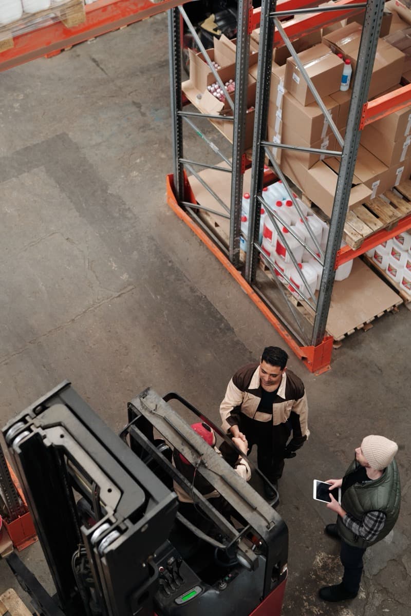 Almacén con racks, pallets y montacargas en operación